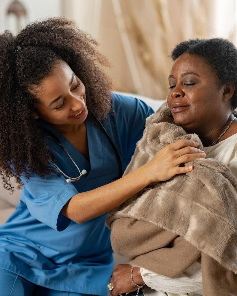 A nurse providing compassionate care to a patient lying in bed.