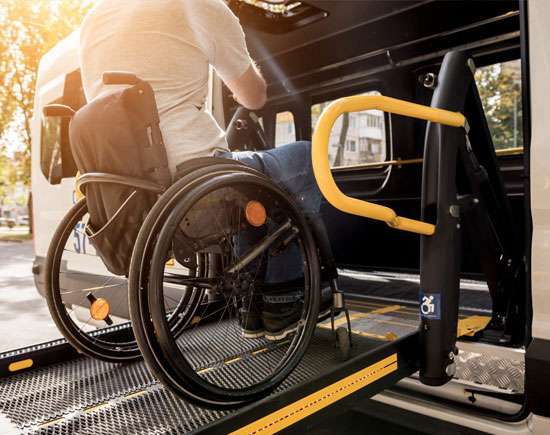 A person in a wheelchair using a lift to enter a vehicle, demonstrating the convenience and accessibility of senior transportation services.