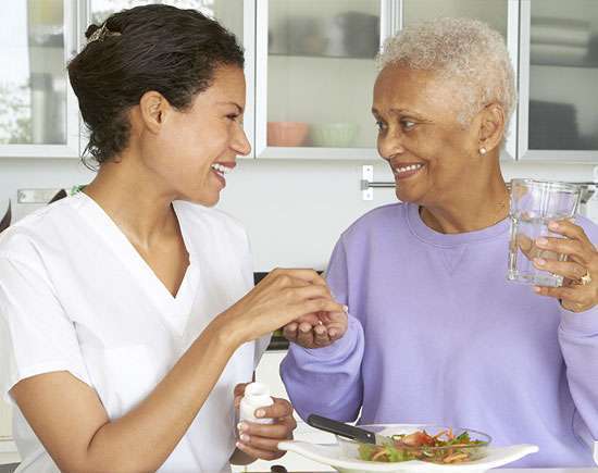 Caregiver assisting a senior with a meal, reinforcing the personalized care and nutritional focus of in-home meal preparation services for seniors.